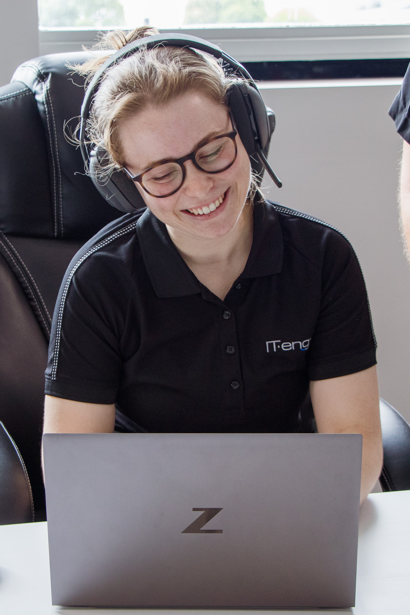 IT Hub - Team member working on laptop while wearing headset
